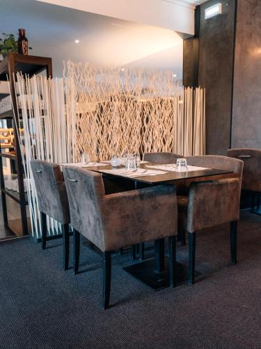 a dining room table with leather chairs at Urban Hotel & Spa Aix-les-Bains - BW Signature Collection in Aix-les-Bains