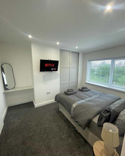 a bedroom with a bed and a clock on the wall at The Crescent-Modern Coastal Home in Blackpool