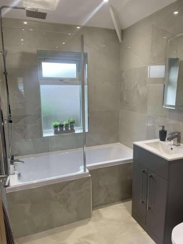 a bathroom with a bath tub and a sink at The Crescent-Modern Coastal Home in Blackpool