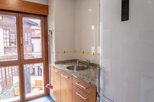 a kitchen with a sink and a refrigerator at Amplio Apartamento en Llanes Centro in Llanes