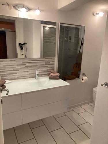 a bathroom with a large white tub and a mirror at Ski Chalet Rinerhorn in Glaris