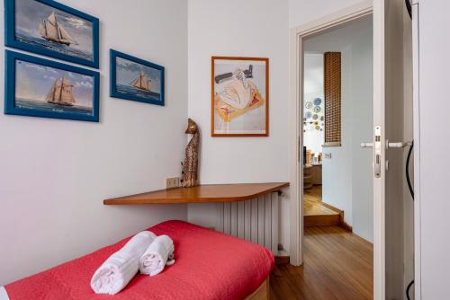 a room with a red bed and a wooden table at Cozy 2-Bedroom Stay at Lido di Venezia in Lido