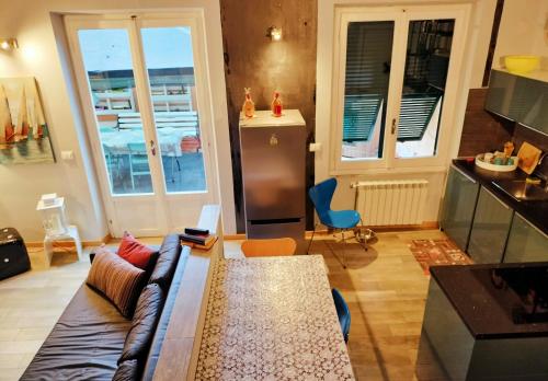 Una sala de estar con un sofá y una cocina. en rubino home, en Sestri Levante