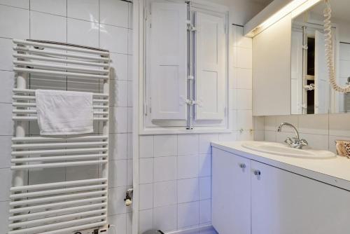 une salle de bain blanche avec un lavabo et un miroir dans l'établissement T2 duplex climatisé à Endoume vue Vieux-Port, à Marseille