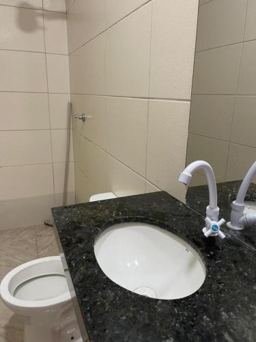 a bathroom with a sink and a toilet at Chácara Recreio 3 in Barra do Garças