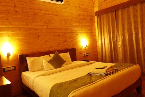 a bedroom with a large white bed with wooden walls at Adhvasaha Beach Spa Resort in Port Blair