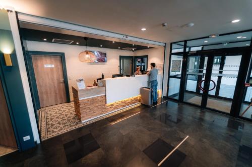 a man standing at a counter in a building at Les Loges du Park in Aix-les-Bains