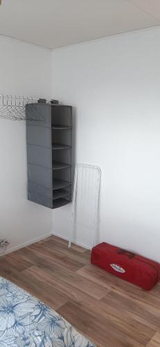 une chambre avec une valise rouge et un fauteuil dans l'établissement Appartement entier paisible proche Tours, à Joué-lès-Tours