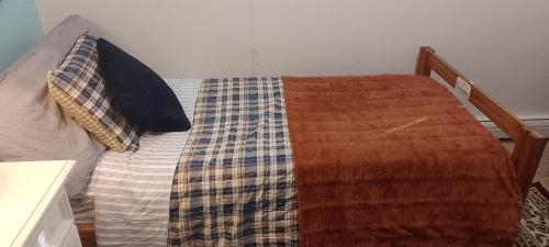 a bed with a blanket and pillows on it at BlueJay Room in Boston