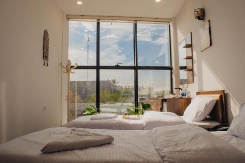 two beds in a room with a large window at شقق دار الزيني - Dar Alzainy Apartments in Baghdad