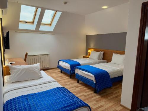 a room with two beds with blue and white sheets at Motel M Vlasenica in Vlasenica