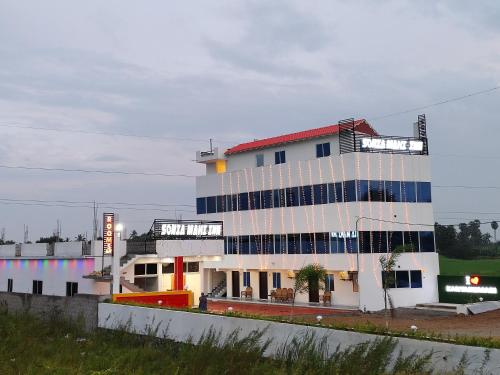 a large white building with a red roof at Hotel SONIA MAHI INN KANYAKUMARI in Kanyakumari