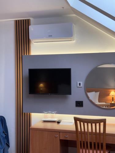 a room with a desk with a tv and a mirror at Motel M Vlasenica in Vlasenica