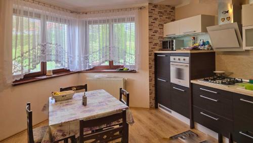 a kitchen with a table and a kitchen with a stove at Clara Valis - Village House in Doľany