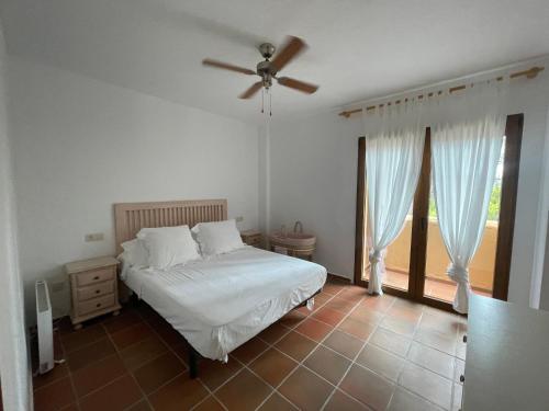 a bedroom with a bed and a ceiling fan at Adosado en Moraira in Teulada