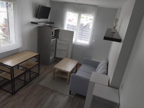 un petit salon avec un canapé et une table dans l'établissement Maison au calme chez stephane, à Boran-sur-Oise