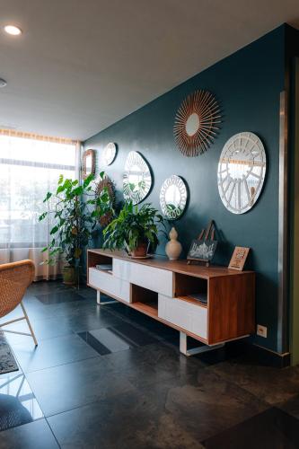 a living room with a table and mirrors on the wall at Les Loges du Park in Aix-les-Bains