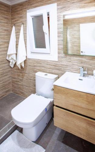 a bathroom with a toilet and a sink and a mirror at Olé studio Apartment in Rojales