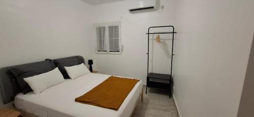 a bedroom with a white bed and a shower at Modern T3 apartement Mamoudzou in Mamoudzou