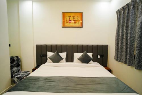 a bedroom with a large white bed and a chair at THE GOVIND PALACE in Ayodhya