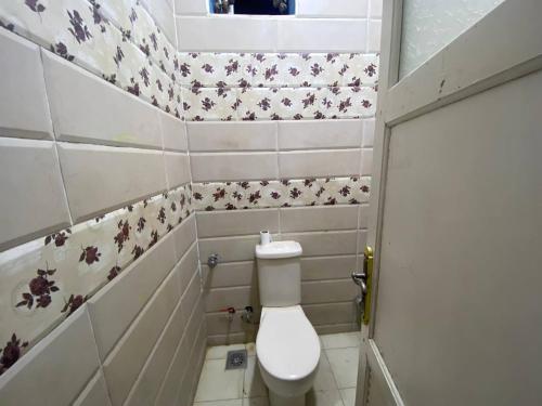 a small bathroom with a toilet in a room at Bakar House in Aswan