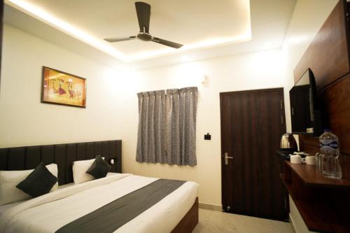 a bedroom with a bed and a ceiling fan at THE GOVIND PALACE in Ayodhya