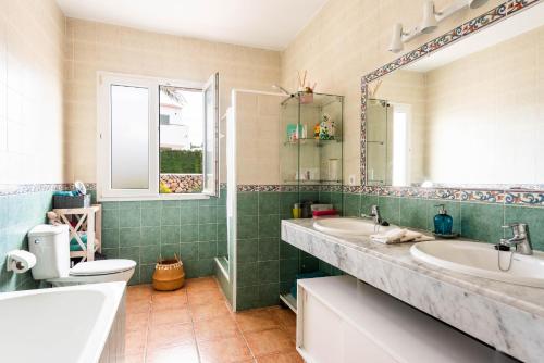 Un baño con dos lavabos y un inodoro. en Villa Las Terrazas - Es Canutells, en Es Canutells