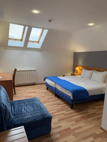a bedroom with a large bed and a couch at Motel M Vlasenica in Vlasenica