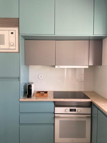 a kitchen with blue and white cabinets and a stove at Casa da Avó in Sesimbra