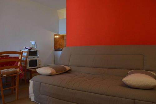 - un salon avec un canapé et un mur rouge dans l'établissement SP500-011 Appt 2 pièces 4 couchages SAINT PIERRE LA MER, à Saint Pierre La Mer