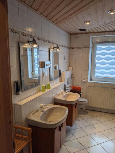 a bathroom with two sinks and a toilet at Gasthaus zum Hirschen in Muhr amSee