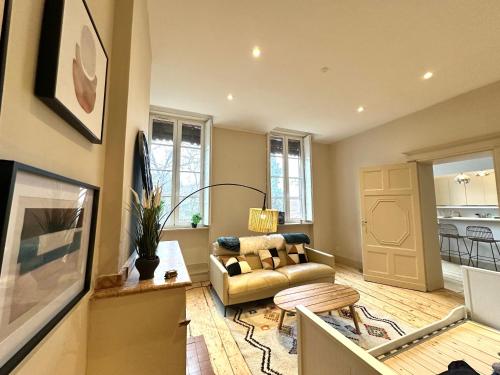 un salon avec un canapé et une table dans l'établissement Grand Appartement Standing Lit King Size Capitole, à Toulouse