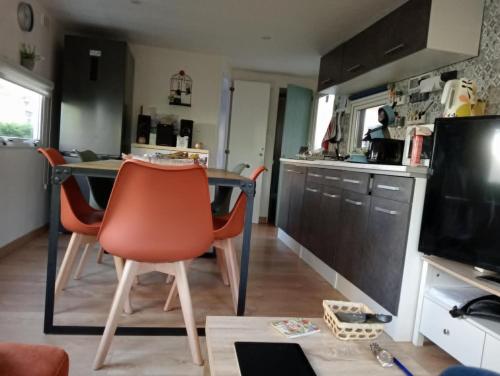une cuisine avec une table et des chaises dans une cuisine dans l'établissement Camping La Lande, à Mimizan