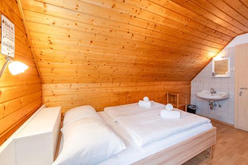 a bed in a room with a wooden ceiling at Matzling Apartment - by myNests in Mitterberg-Schladming-Dachstein