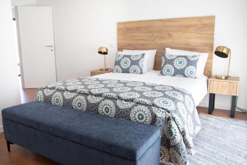 a bedroom with a large bed with a wooden headboard at Casa da Praceta - BY SCH in Alfeizerão