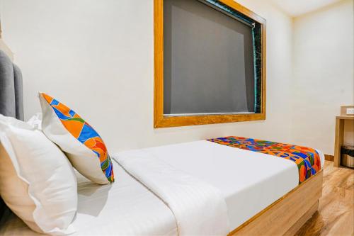 a small room with a bed and a window at FabHotel Riza International - Nr Nesco Exhibition Centre in Mumbai