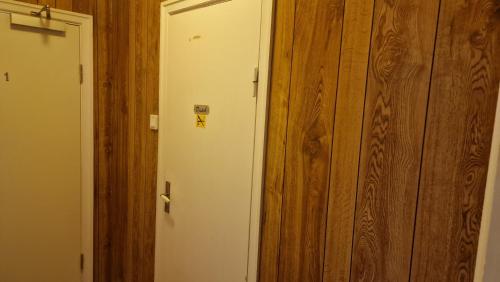a door with a sticker on it next to a wooden wall at Charlottsborgs Camping och Vandrarhem in Kristianstad