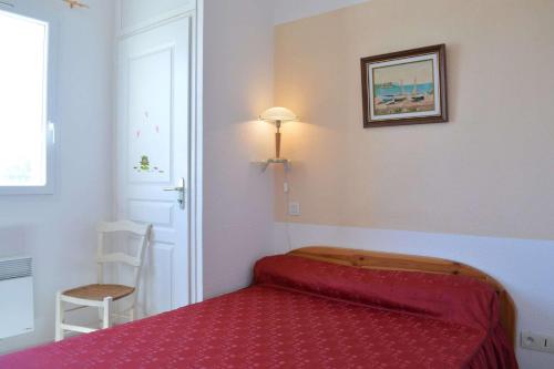 une chambre avec un lit rouge dans une pièce dans l'établissement SP340-008 Mais 2 pièces mezz 6 couchages SAINT PIERRE LA MER, à Saint Pierre La Mer