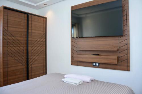 a bedroom with a tv and a bed with towels at Copacabana Apartment - Sea View in Kenitra