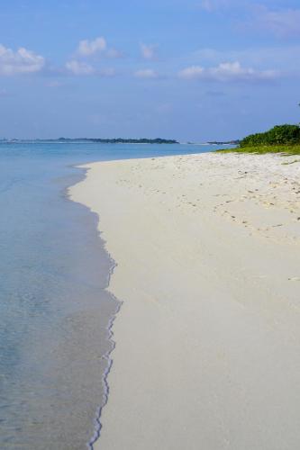 a sandy beach with the ocean in the background at Sun & Surf in Thulusdhoo