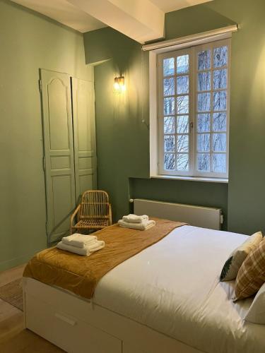 une chambre avec un grand lit et une fenêtre dans l'établissement Le clos du Tilleul - charme en hyper centre, à Caen