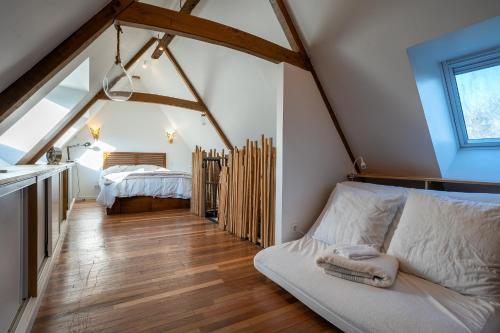 une chambre avec un lit dans un grenier avec du parquet dans l'établissement Ty Claire - Grandes terrasses et jardin, à Plouhinec