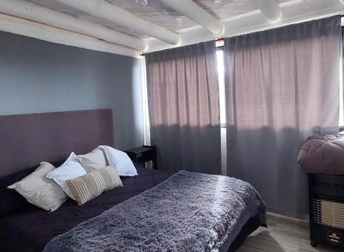 a bedroom with a bed with white pillows on it at Casa MoodSpot Potrerrillos vistas 360 in Cacheuta