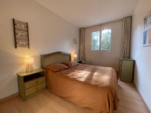 une chambre avec un lit avec deux lampes et une fenêtre dans l'établissement Appartement 60m2 piscine au coeur de Saint-Tropez, à Saint-Tropez