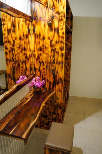 a room with a bench and flowers on a wall at Sun & Surf in Thulusdhoo
