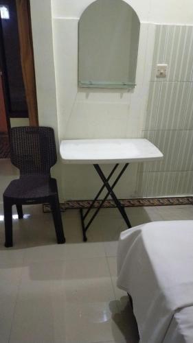 a chair and a table and a mirror in a room at Wisma Kencana in Rantepao