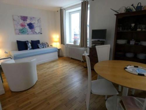 un salon avec un canapé et une table dans l'établissement appartement fleurs, à Loctudy