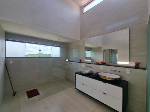 a large bathroom with a sink and a shower at Fazenda de Jehne in Camamu