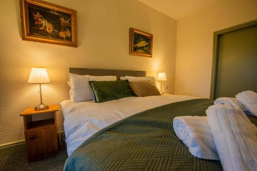 a bedroom with a large bed and a table with a lamp at Greenfield Lodge Hotel Bar & Bistro in Headford
