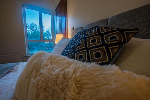 a white blanket laying on a bed with a pillow at Greenfield Lodge Hotel Bar & Bistro in Headford